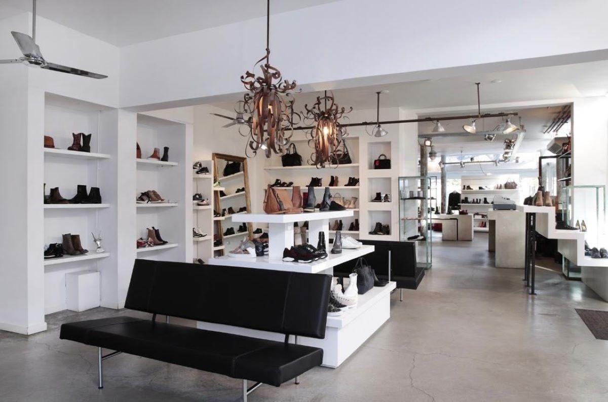 binnen in de winkel Shoebox met veel schoenen en een bank